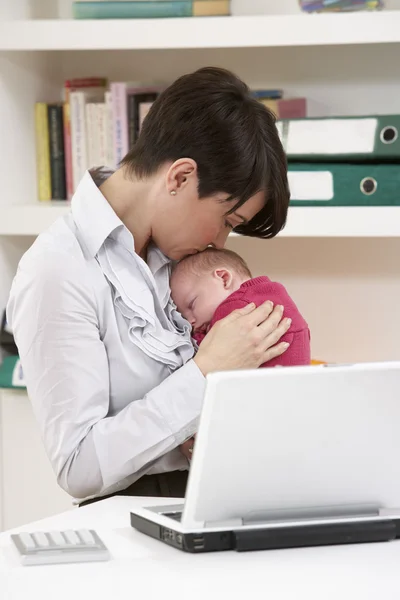 Mulher com bebê recém-nascido trabalhando de casa usando laptop — Fotografia de Stock