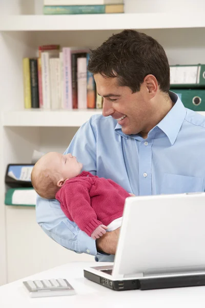 Pai com bebê recém-nascido trabalhando a partir de casa usando laptop — Fotografia de Stock