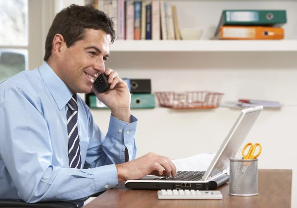 Man som arbetar hemifrån med laptop på telefon — Stockfoto