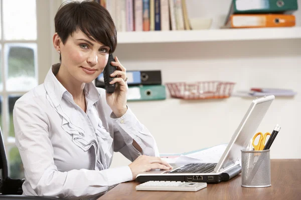 Vrouw werken vanuit huis met behulp van laptop op telefoon — Stockfoto