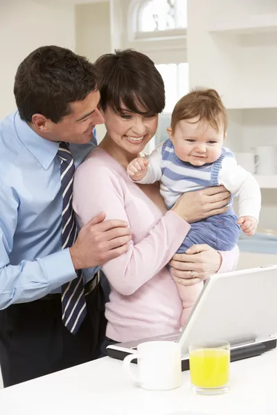 Pais com bebê trabalhando a partir de casa usando laptop — Fotografia de Stock