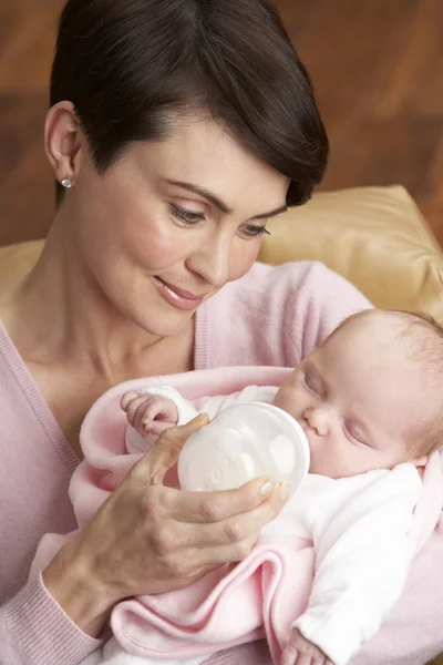 Portret van moeder voeding pasgeboren baby thuis — Stockfoto