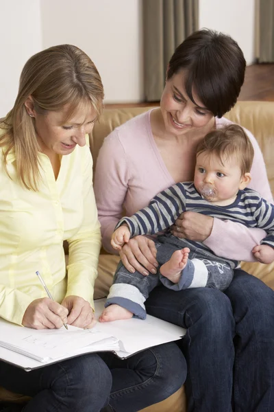 stock image Mother With Baby Talking With Health Visitor At Home