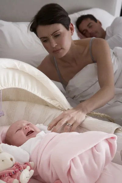 Nouveau-né pleurant dans le lit bébé dans la chambre des parents — Photo