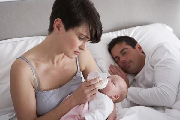 Мать кормит новорожденного ребенка в постели дома — стоковое фото
