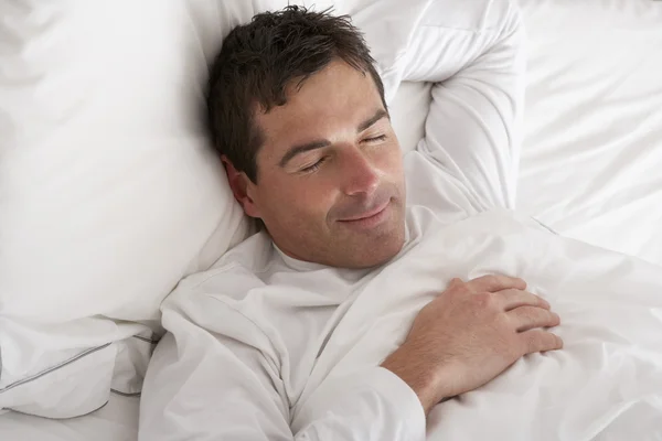 Homem dormindo pacificamente na cama — Fotografia de Stock