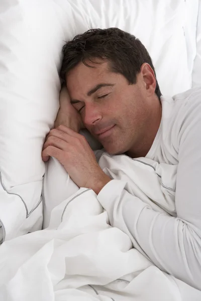 Człowiek śpi spokojnie w łóżku — Zdjęcie stockowe