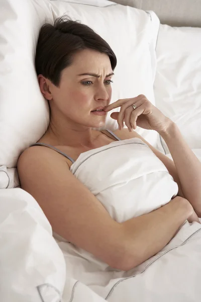 Mulher preocupada deitada acordada na cama — Fotografia de Stock