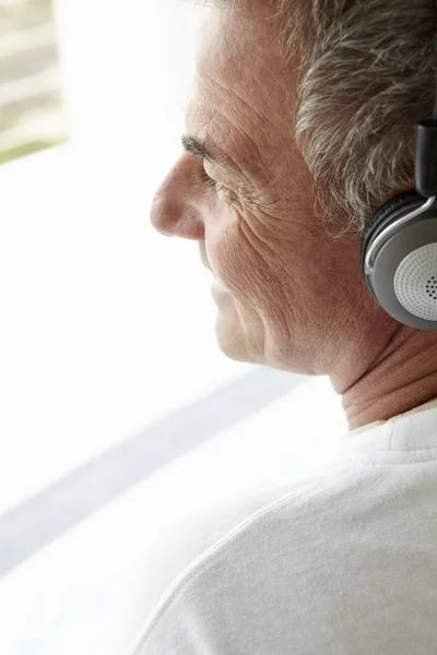 Mitten av ålder man bär hörlurar — Stockfoto