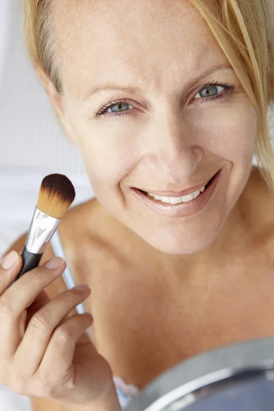 Mid age woman putting on make-up — Stock Photo, Image
