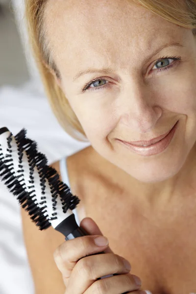 Mujer de mediana edad sosteniendo cepillo —  Fotos de Stock