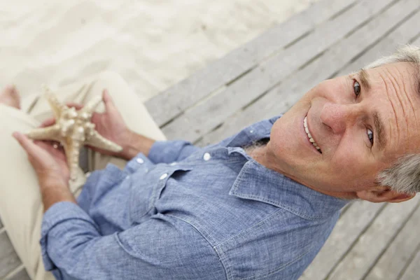 Hombre mayor sosteniendo estrellas de mar —  Fotos de Stock