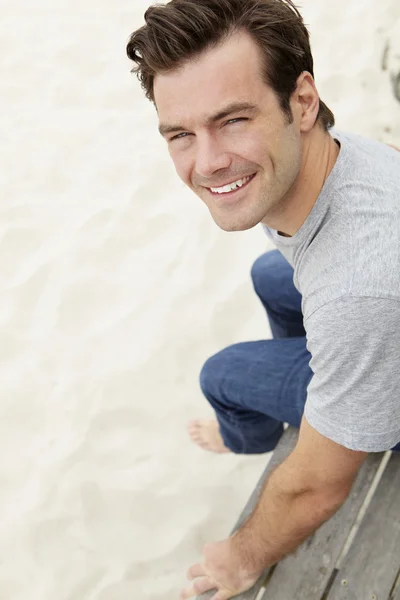 Retrato hombre sentado junto a la playa — Foto de Stock