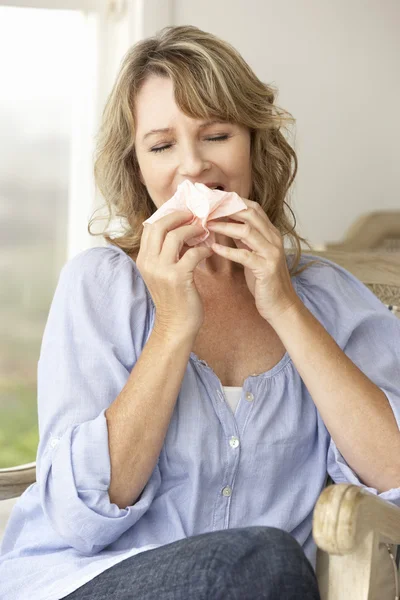 Mujer de mediana edad estornudando — Foto de Stock