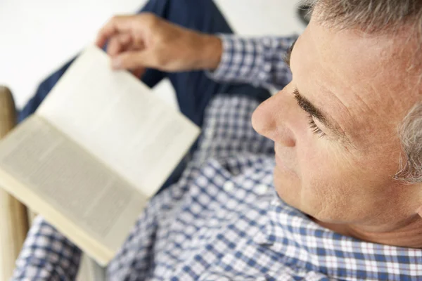 Человек среднего возраста читает книгу — стоковое фото