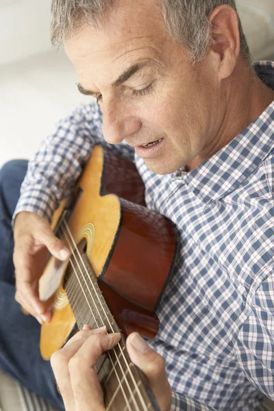 Мужчина среднего возраста играет на акустической гитаре — стоковое фото