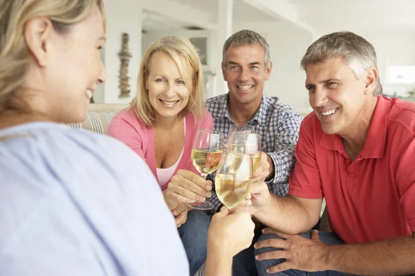 Midden leeftijd paren drinken samen thuis — Stockfoto
