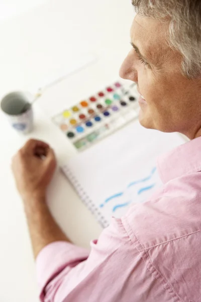 Человек средних лет рисует акварелью — стоковое фото