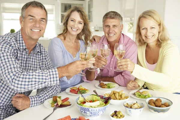 Parejas de mediana edad disfrutando de la comida en casa —  Fotos de Stock