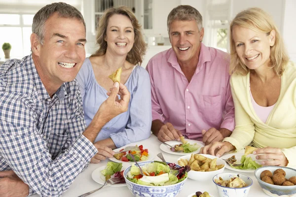 Casais de meia idade desfrutando de refeição em casa — Fotografia de Stock