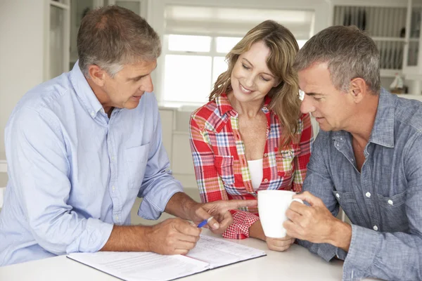 Mid age couple with financial advisor at home — Stock Photo, Image