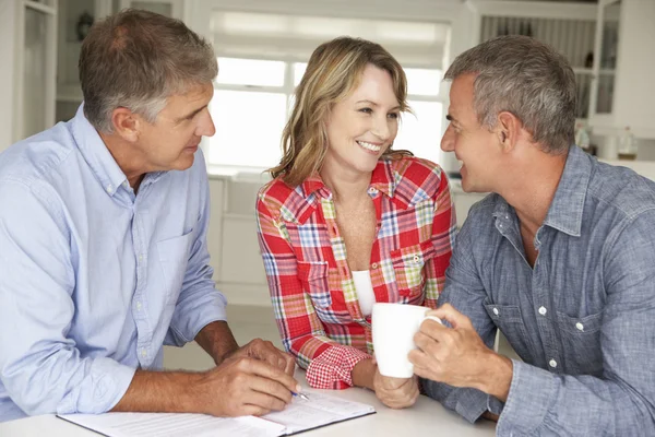 Couple d'âge moyen avec conseiller financier à domicile — Photo