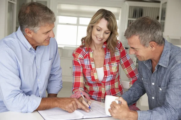 Midden leeftijd paar met financieel adviseur thuis — Stockfoto