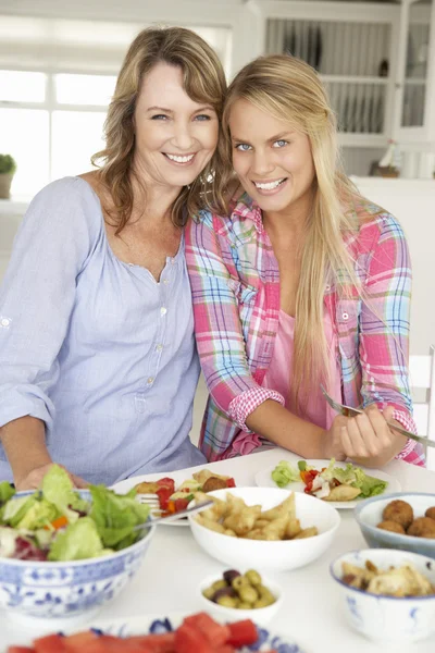 母親と 10 代の娘を自宅で食事を楽しむ — ストック写真