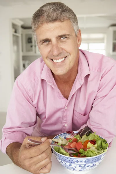 Mann mittleren Alters isst Salat — Stockfoto