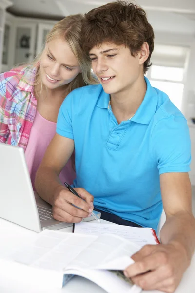 Adolescente menino e menina fazendo lição de casa com laptop — Fotografia de Stock