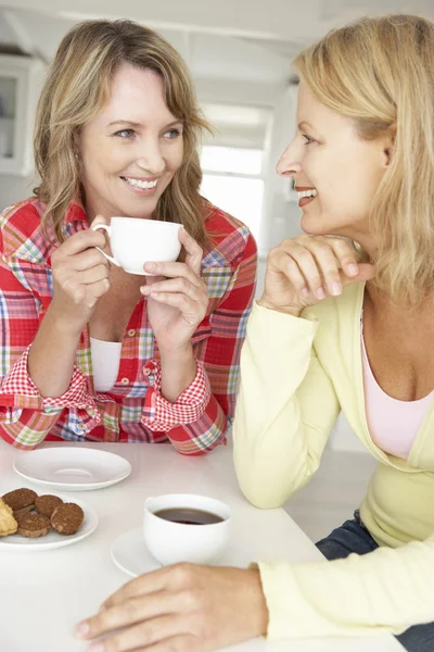 中間年齢の女性が自宅でコーヒーを飲みながら談笑 — ストック写真