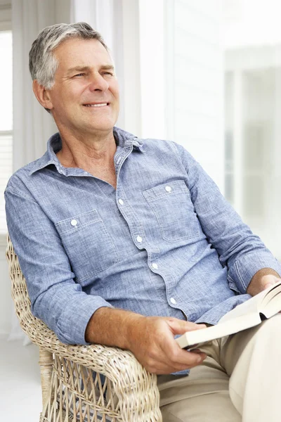 Senior man thuis ontspannen met een boek — Stockfoto