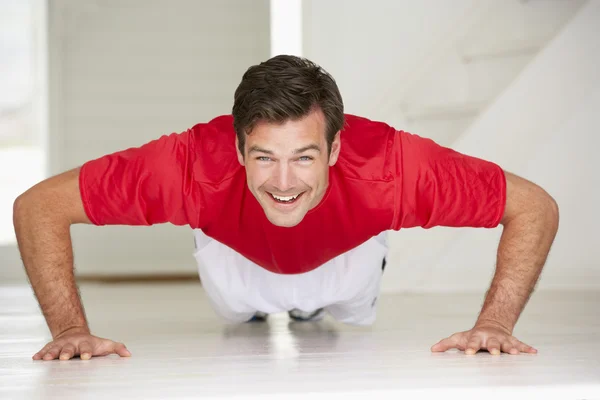 Hombre haciendo flexiones en el gimnasio en casa —  Fotos de Stock