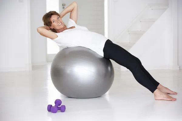 Mulher sênior usando bola de ginásio — Fotografia de Stock