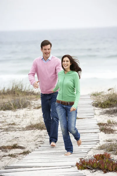 Paar läuft Strandweg entlang — Stockfoto