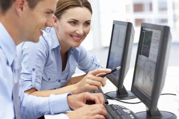 Бизнесмен и женщина работают за компьютерами — стоковое фото