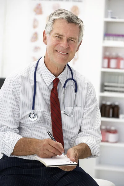 Médico sênior que escreve prescrição — Fotografia de Stock