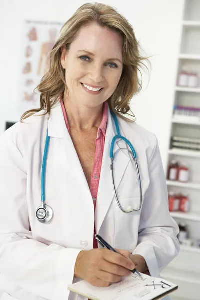 Średni wiek kobiet lekarz pisze receptę — Zdjęcie stockowe