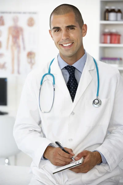 Young male doctor writing prescription — Stock Photo, Image