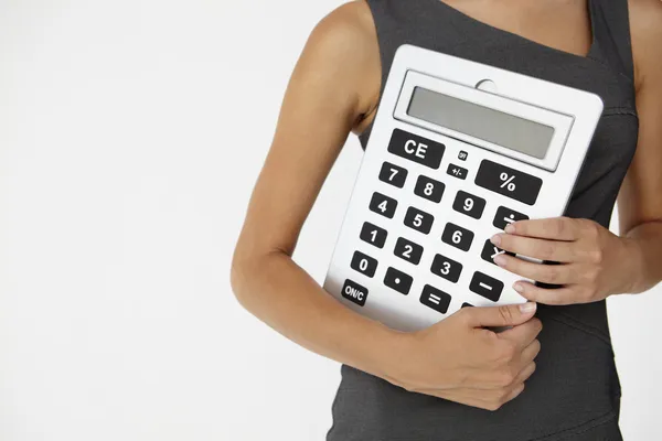 Jonge zakenvrouw met gigantische calculator — Stockfoto