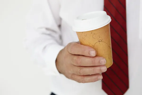 Biznesmen gospodarstwa wywoławcza kawy — Zdjęcie stockowe