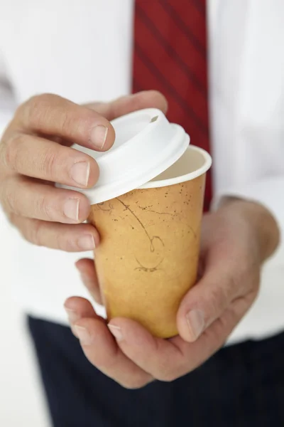 Бизнесмен держит кофе на вынос — стоковое фото