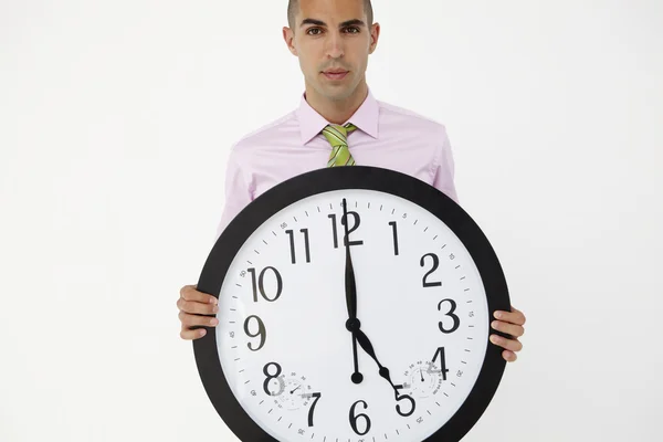 Jeune homme d'affaires avec horloge géante — Photo