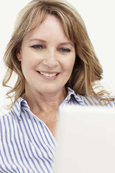 Mujer de negocios de mediana edad usando computadora portátil — Foto de Stock