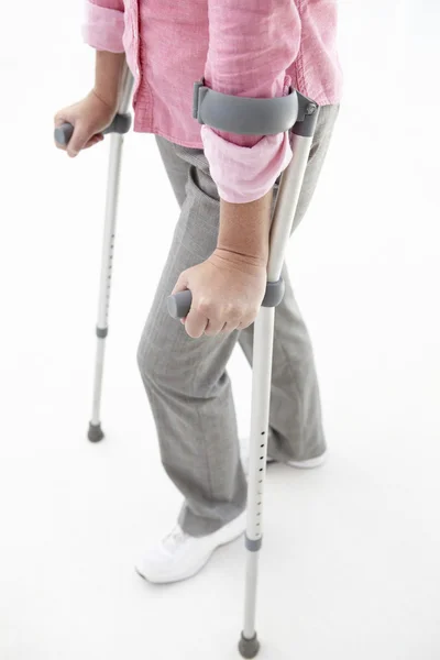 Mulher andando com muletas — Fotografia de Stock