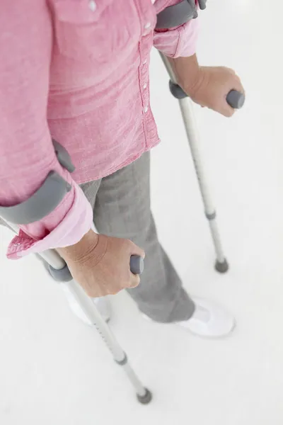 Mujer caminando con muletas — Foto de Stock