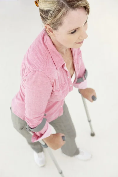 Woman walking with crutches — Stock Photo, Image