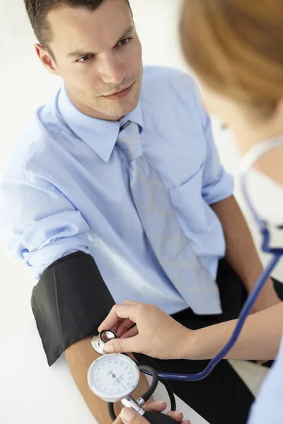 Junger Mann lässt sich Blutdruck entnehmen — Stockfoto