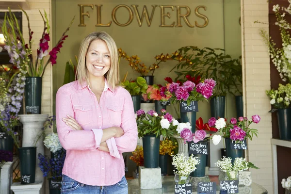 Frau steht vor Blumengeschäft — Stockfoto
