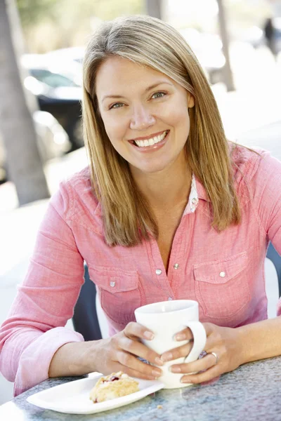 Woman sitting at sidewalk café — Stok fotoğraf
